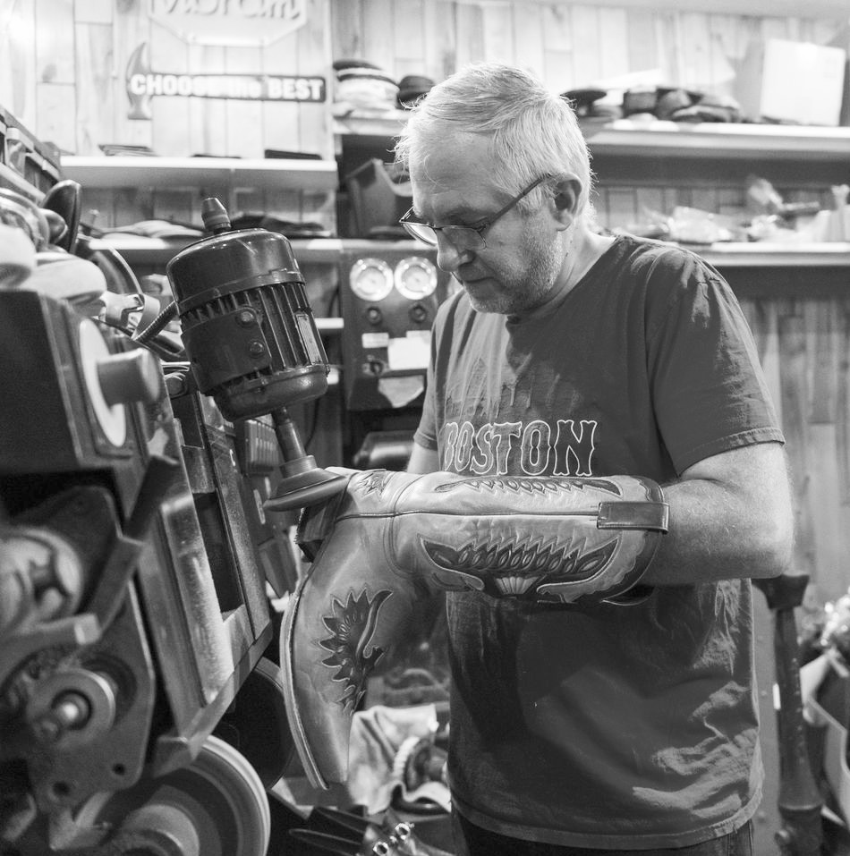 The cobbler at work on a leather boot at the finishing machine